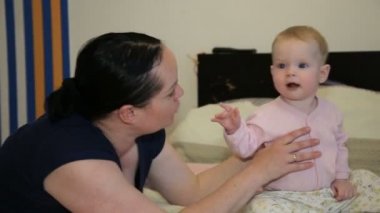 Anne ve bebek oynama ve evde gülümseyen