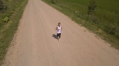 Kız bir alan yolu üzerinde çalışır. Havadan görünümü.