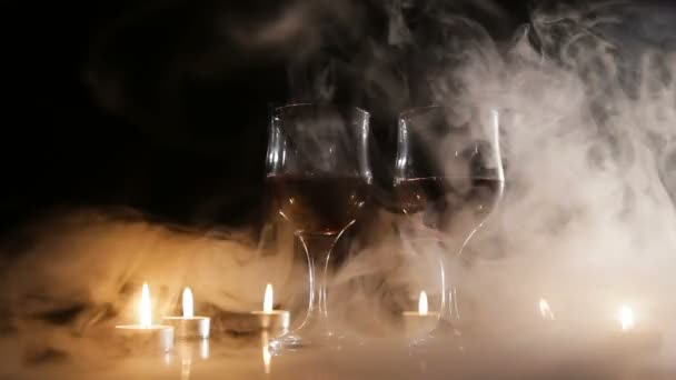 Copas de vino y velas encendidas en el humo . — Vídeos de Stock