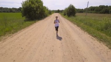 Kız bir alan yolu üzerinde çalışır. Havadan görünümü.