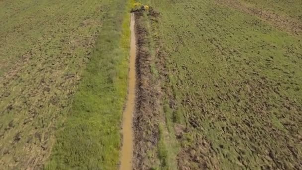 Escavadeira cavando uma trincheira no campo.Vídeo aéreo . — Vídeo de Stock