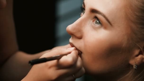 Maquillar artista haciendo profesional maquillaje de mujer joven — Vídeo de stock