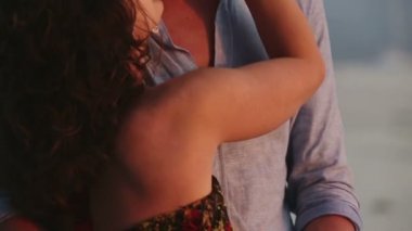 Sahilde duran ve gün batımı arıyorum genç Çift