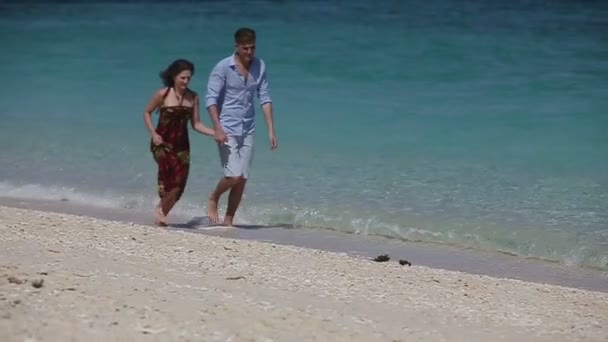 Feliz pareja corriendo en tropical playa . — Vídeos de Stock