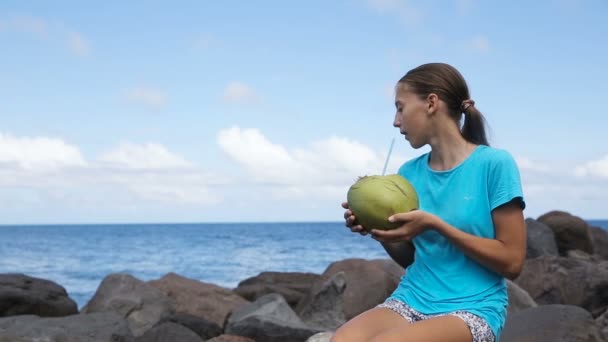 Дівчина-підліток п'є кокосовий сік — стокове відео