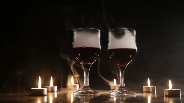 Verres à vin et bougies brûlantes dans la fumée . — Video