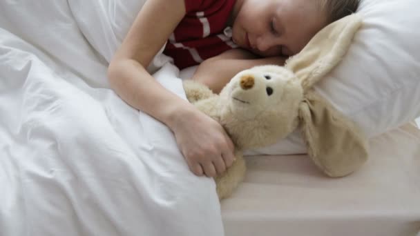 Маленькая девочка спит в своей постели — стоковое видео