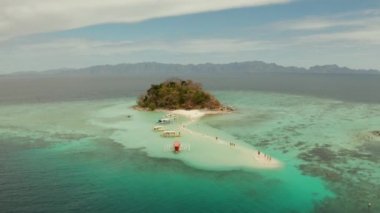 Beyaz kumlu sahili olan küçük torpik bir ada..