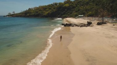 Kumsalda yürüyen bir kız. Bali, Endonezya.