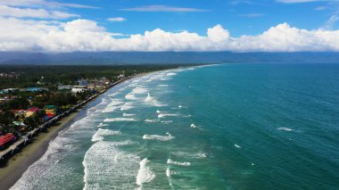 Turistler ve sörfçülerle dolu bir kumsal. Baler Filipinleri