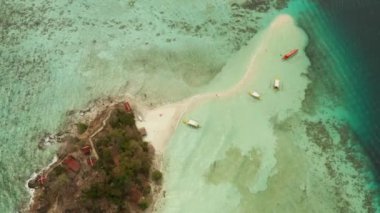 Beyaz kumlu sahili olan küçük torpik bir ada..