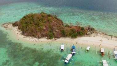Beyaz kumlu sahili olan küçük torpik bir ada..
