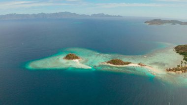 Beyaz kumlu sahili olan küçük torpik bir ada..