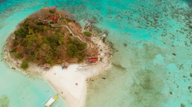 Beyaz kumlu sahili olan küçük torpik bir ada..