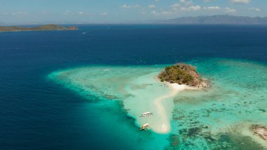 Beyaz kumlu sahili olan küçük torpik bir ada..