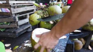 Taze hindistan cevizi doğrayan bir adam..