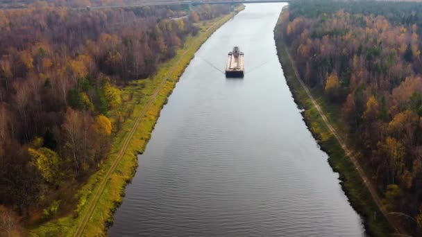 Schlepper bewegt Frachtkahn auf dem Fluss. Herbstliche Landschaft. — Stockvideo