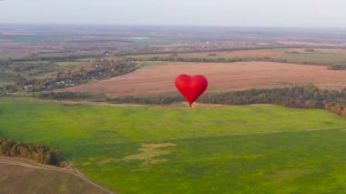Sıcak hava balonu günbatımında gökyüzünde kalbi şekillendirir..