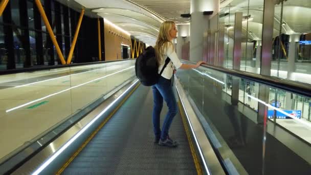 Mujer en escalera mecánica en el aeropuerto internacional. — Vídeo de stock