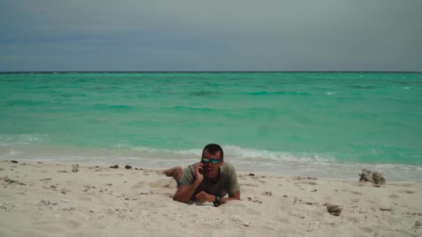 Homme avec téléphone portable sur la plage. — Video