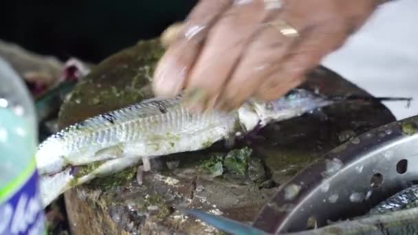 Mulher está cortando peixe em um mercado de frutos do mar. — Vídeo de Stock