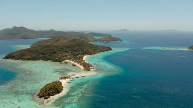 Beyaz kumlu sahili olan küçük torpik bir ada..