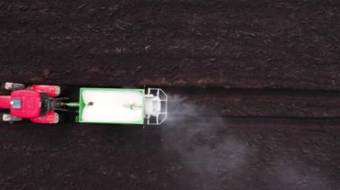 Traktör tarlaya kuru mineral gübreleri yayar..