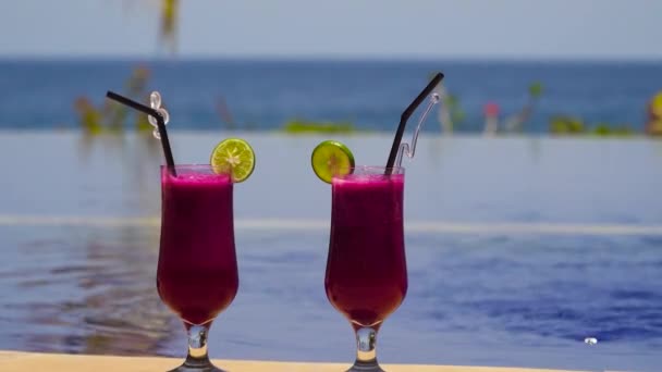 Glasses with a cocktail near the pool. — Stock Video
