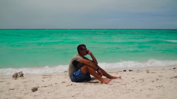 Homme avec téléphone portable sur la plage tropicale. — Video