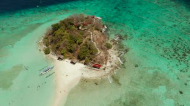 Beyaz kumlu sahili olan küçük torpik bir ada..