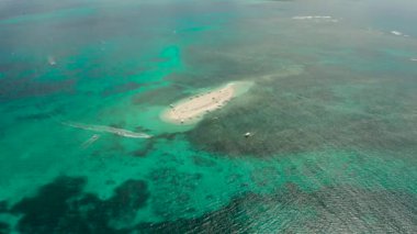 Kumsalı ve turistleri olan kumlu bir ada. Çıplak Ada, Siargao