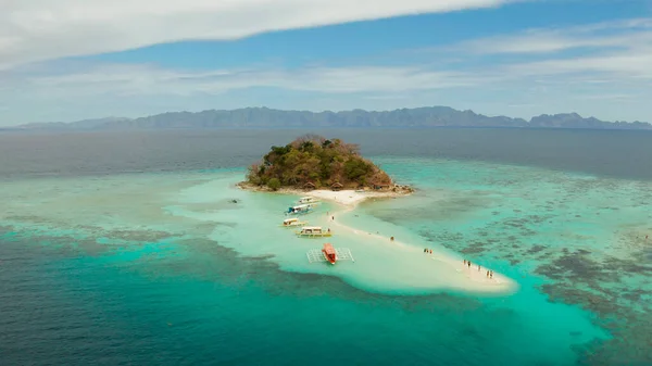 Beyaz kumlu sahili olan küçük torpik bir ada..