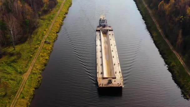 O rebocador fluvial move a barcaça de carga no rio. Paisagem de outono. — Vídeo de Stock
