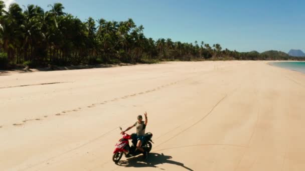 Mężczyzna prowadzący motocykl na plaży. — Wideo stockowe