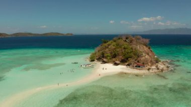 Beyaz kumlu sahili olan küçük torpik bir ada..