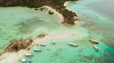 Beyaz kumlu sahili olan küçük torpik bir ada..