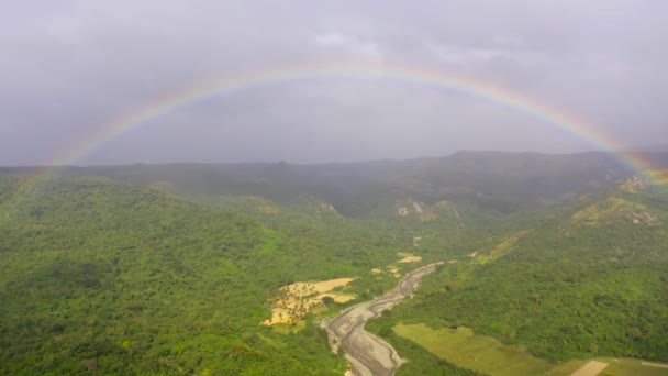 Regenbogen über dem Fluss im Hochland. Berge auf der Insel Luzon, Philippinen. — Stockvideo