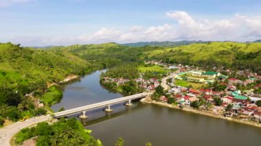 Nehir kıyısındaki kasaba ve karayolu köprüsü, üst manzara. Filipinler 'deki Samar adasında yol köprüsü.
