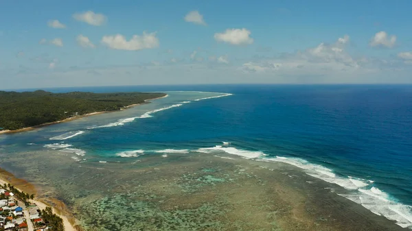 The coast of Siargao island, blue ocean and waves.