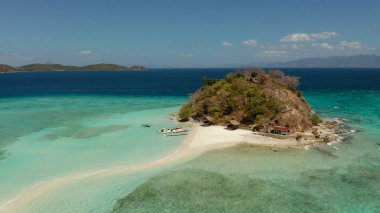 Beyaz kumlu sahili olan küçük torpik bir ada..