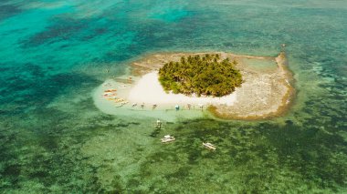 Kumlu plajı ve turistleri olan tropik Guyam Adası.