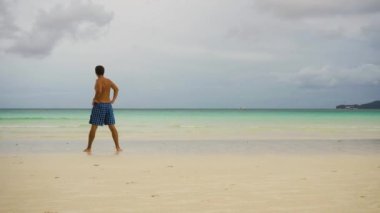 Sahilde sabah egzersizi yapan bir adam..