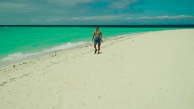 Kumsalda yürüyen bir adam.