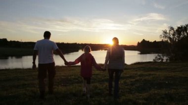 Yaz günbatımı üzerinde insan siluetleri