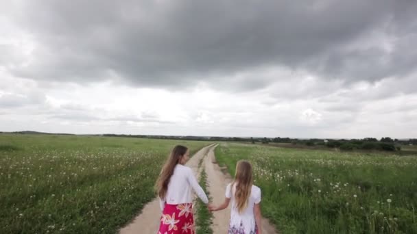 Young girls walking holding their hands — Stock Video