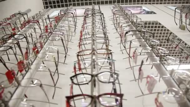 Полка с современными, красивыми, цветными очками — стоковое видео