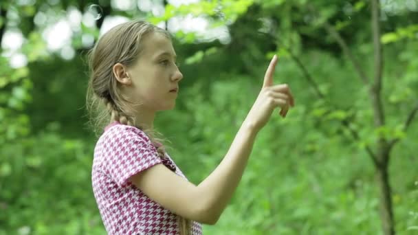 Young girl catches soap bubbles in the park — Stock Video