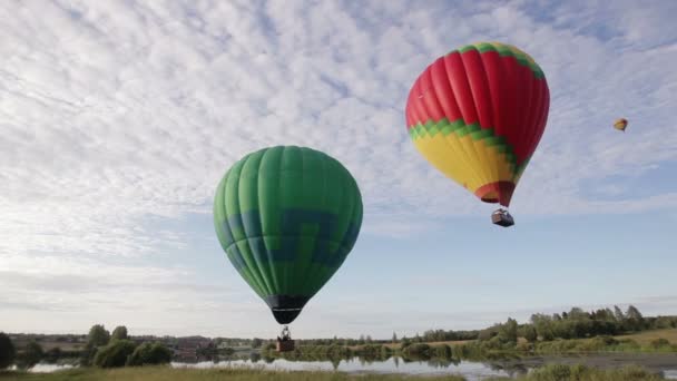 Balões de ar quente voando sobre lago e campo — Vídeo de Stock