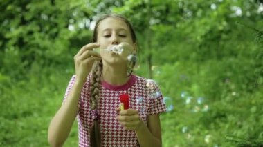 Genç kız açık sabun köpüğü üfleme