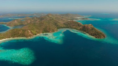 Mavi lagünü, mercan kayalıkları ve kumlu plajı olan tropikal adalar. Palawan, Filipinler. Turkuaz lagünlü Malezya adaları..